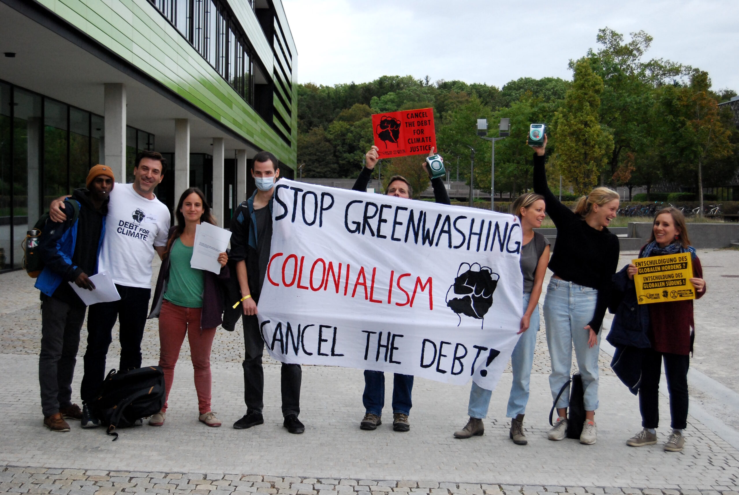 Wer schuldet hier wem etwas: Debt for Climate stört Greenwashing-Konferenz in München