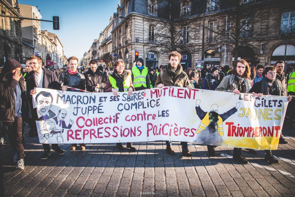 Gelbwesten in Bordeaux mit Banner gegen Polizeigewalt